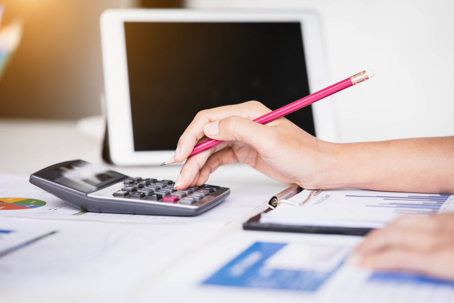 Woman working at a desk calculating economic recovery